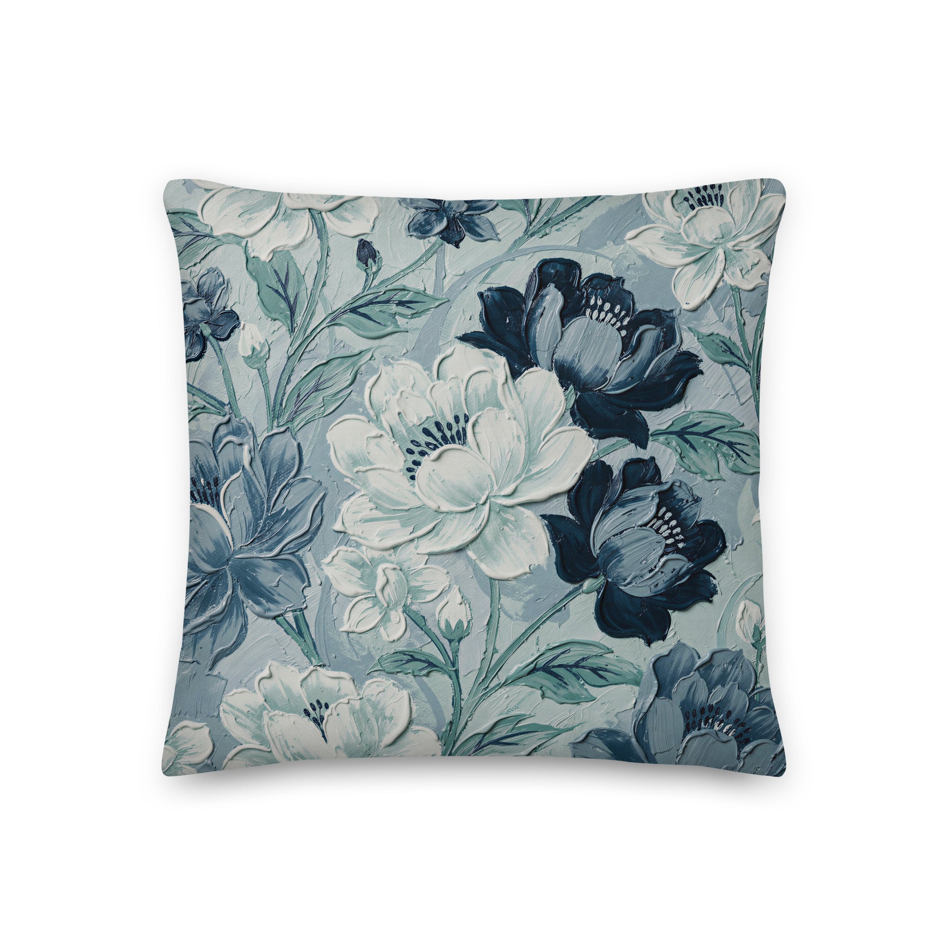 Blue botanical cushion with navy, pale blue and slate-blue flowers and blue-green foliage on a pale blue background.