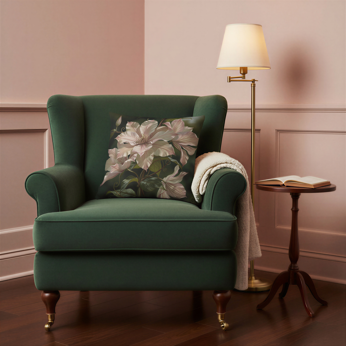 Square cushion featuring painterly pale pink and cream clematis flowers growing along twisting stems, with glossy olive-green leaves against a dark botanical background.